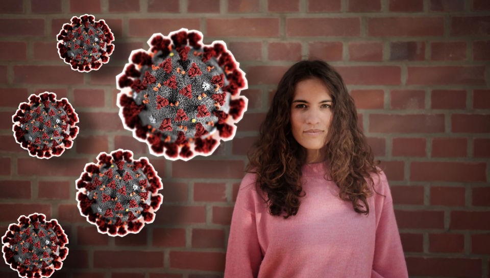 Reporterin Mona steht vor einer roten Mauerwand, neben ihr die grafische Darstellung des neuen Coronavirus 2019-nCoV