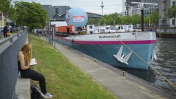 Das Ausstellungsschiff "MS Wissenschaft" liegt in einem Hafen vor Anker.