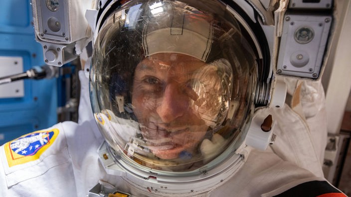Astronaut Matthias steckt in einem weißen Raumanzug