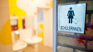 Ein Schild "Schülerinnen" hängt an einer Schultoilette