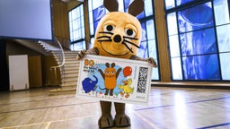 Die Maus präsentiert eine Briefmarke mit Maus, Elefant und Ente.