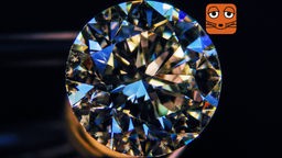 Ein geschliffener Diamant funkelt in den Farben Blau, Türkis und Weiß.