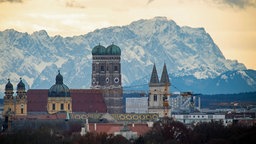 Die Skyline der Stadt München vor der Kulisse der etwa 90 Kilometer entfernten Alpen mit der Zugspitze.