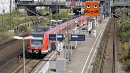 Ein roter Zug der Deutschen Bahn fährt in einen Bahnhof ein.