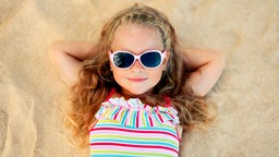 Mädchen mit Sonnenbrille am Strand