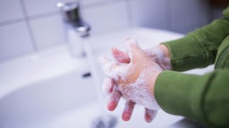 Eingeschäumte Kinderhände im Waschbecken