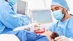 Chirurg und Anästhesist arbeiten zusammen bei der Betäubung von Patient vor der Operation