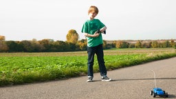 Junge spielt mit ferngesteuertem Auto