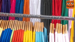 Kleider hängen an Bügeln an einer Kleiderstange