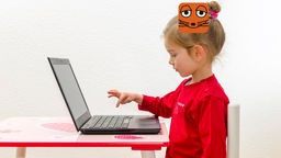 Kind sitzt vor einem Laptop