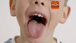 Ein kleiner Junge streckt die Zunge raus und seine Zähne sind zu sehen.