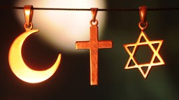 Die religiösen Symbole Halbmond für den Islam, das Kreuz für das Christentum und der Davidstern für das Judentum.