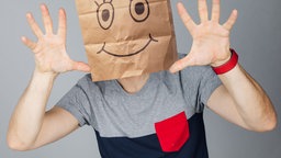 Moderator André mit einer Papiertüte auf dem Kopf