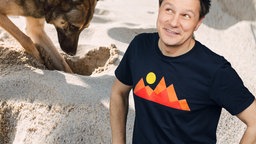André neben buddelndem Hund im Sand