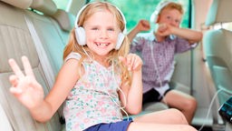 Kinder im Auto mit Kopfhörern
