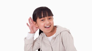 Ein Mädchen legt seine Hand lauschend an sein Ohr