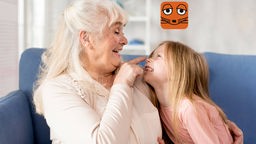 Oma tippt ihrer Enkelin auf die Nase