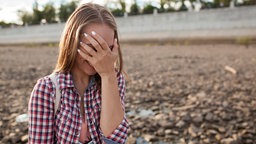 Mädchen hält sich die Hand vor die Augen