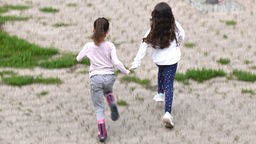Zwei Mädchen laufen über den Schulhof