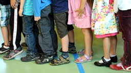 Kinderbeine stehen hintereinander in einer Schlange