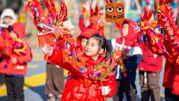 Kinder machen einen Drachentanz in China