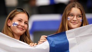 Zwei weibliche lachende finnische Fans