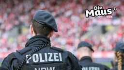 Ein Polizist in Uniform im Stadion von hinten