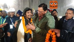 28.11.2023, Indien, Silkyara: Pushkar Singh Dhami (r), Ministerpräsident von Uttarakhand, begrüßt einen Arbeiter, der aus dem eingestürzten, sich im Bau befindenden, Tunnel gerettet wurde.