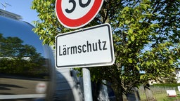 Ein Tempo-30-Schild steht am Straßenrand, darunter heißt es: Lärmschutz
