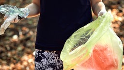 Frau beim Plogging: Joggen und Müll sammeln