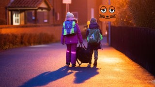 Zwei Kinder gehen im Dunkeln zur Schule