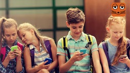 4 Kinder sitzen nebeneinander und schauen auf ihre Handys. Sie sind alle versunken und fasziniert von den Inhalten auf ihrem Smartphone. 