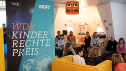 Kinder und Erwachsene sitzen bei der Preisverleihung des WDR-Kinderrechtepreises in Sesseln