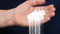 Salz rieselt aus einer Hand