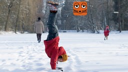 Kind macht einen Handstand im Schnee