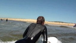 Surfcamp - Surfer schaut zum Land nach einem Fixpunkt