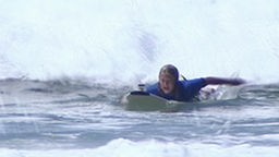 Das Surfcamp - Kim paddelt vor einer Welle