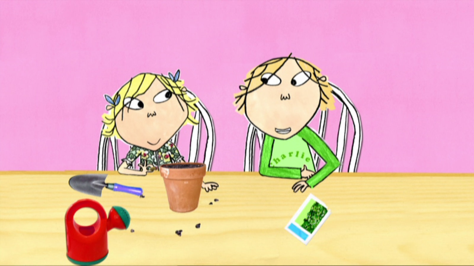 Charlie und Lola sitzen am Tisch und pflanzen Samenpflanzen in einen Blumentopf