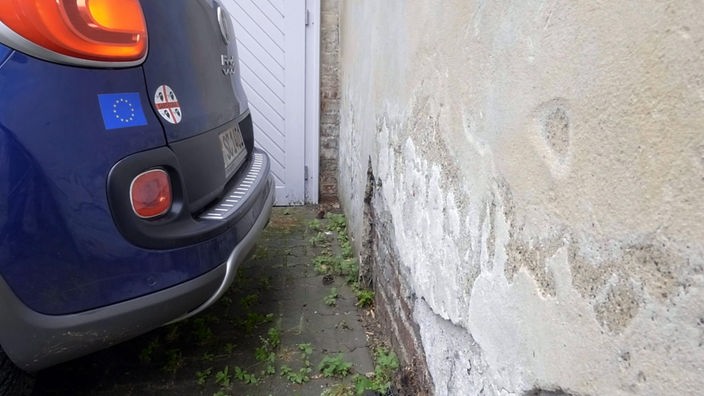 Ein Rücklicht eines dunkelblauen Autos vor einer Wand
