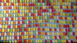Gummibärchen in unterschiedlichen Farben liegen aufgereiht nebeneinander