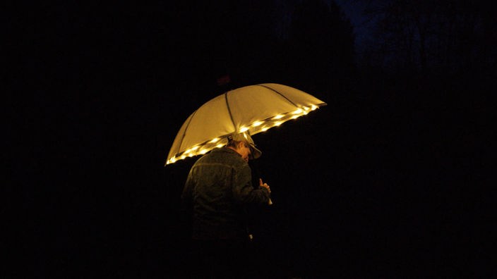 Leuchtender Regenschirm im Dunkeln