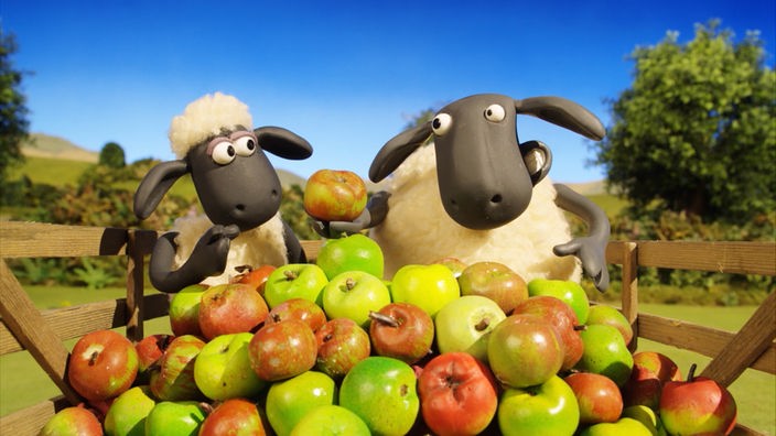 Zwei Schafe vor einem Berg Äpfel