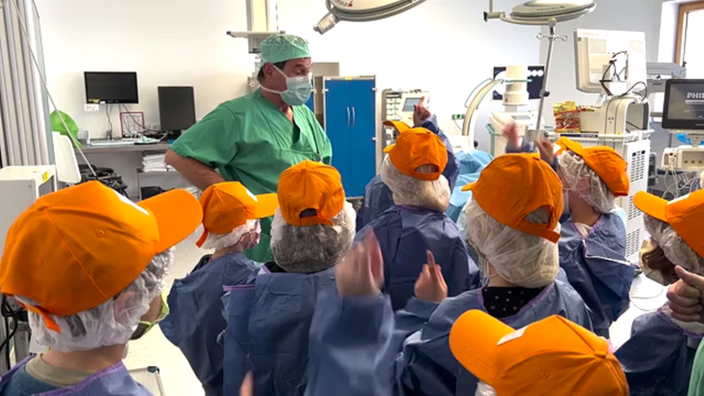 Ein Arzt der Regio Kliniken spricht mit einer Gruppe von Schülern.