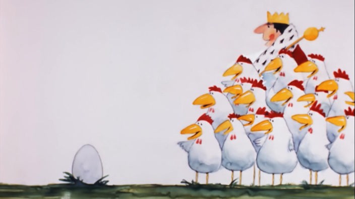 Eine Gruppe von Hühnern und ein König schauen auf ein einzelnes Ei auf einer Wiese  