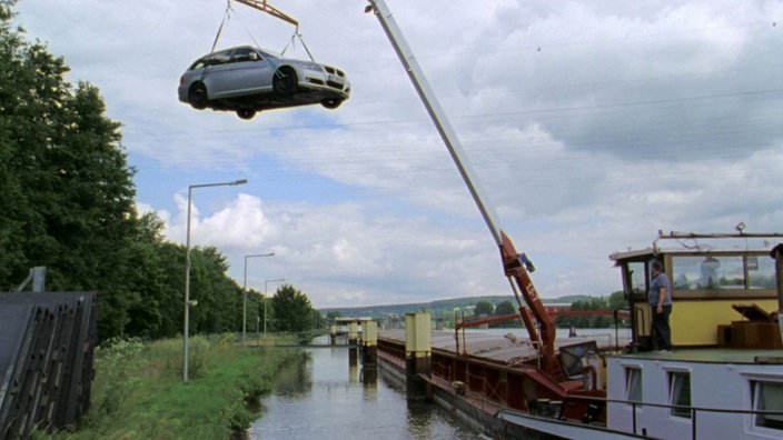 Ein Auto hängt an einem Schiffskran