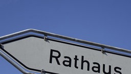 Weißes Schild mit schwarzem Schriftzug 'Rathaus'.