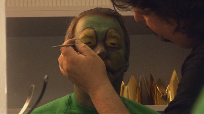 Maskenbildnerin schminkt Christoph für den Karneval