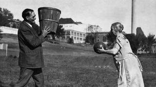 James Naismith, der Erfinder des Basketball, demonstriert den Sport mit seiner Frau Maude auf einer Wiese.