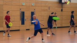 Ultimate Frisbee - Spieler trainieren in Sporthalle.