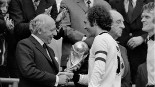 Schwarz-weiß Foto: Der ehemalige Bundespräsident Walter Scheel überreicht den WM-Pokal an Franz Beckenbauer.